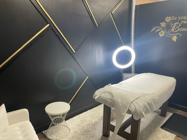 Waxology treatment room with ring light and 'Be your own Beauty' wall